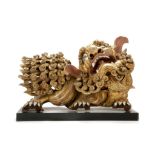 A PAIR OF GOLD PAINTED WOODEN LIONS. Late Qing. Excessively carved in high relief with swirling