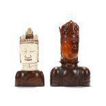 TWO CARVED GUANYIN HEADS, ONE OF HORN, THE OTHER BONE. Late 19th Century. Raised on wooden stands