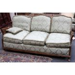 A Bergere sofa and chairs, walnut with double carved sides, leaf carving to apron, stub pad feet,