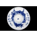 A BLUE AND WHITE SAUCER DISH. Kangxi mark and of the period. Decorated around a central raised