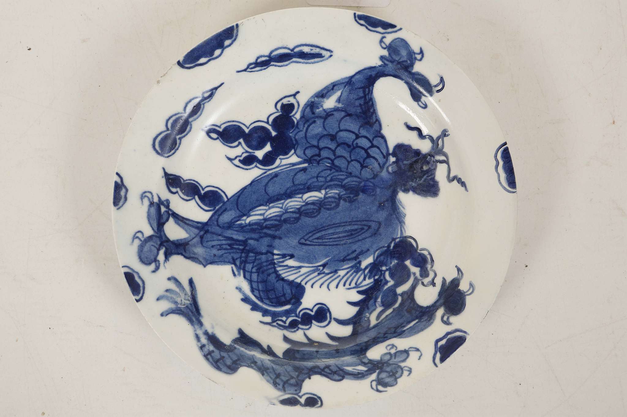 A SMALL BOW PLATE, circa 1760, painted in underglaze blue with the 'Dragon' pattern (14cm