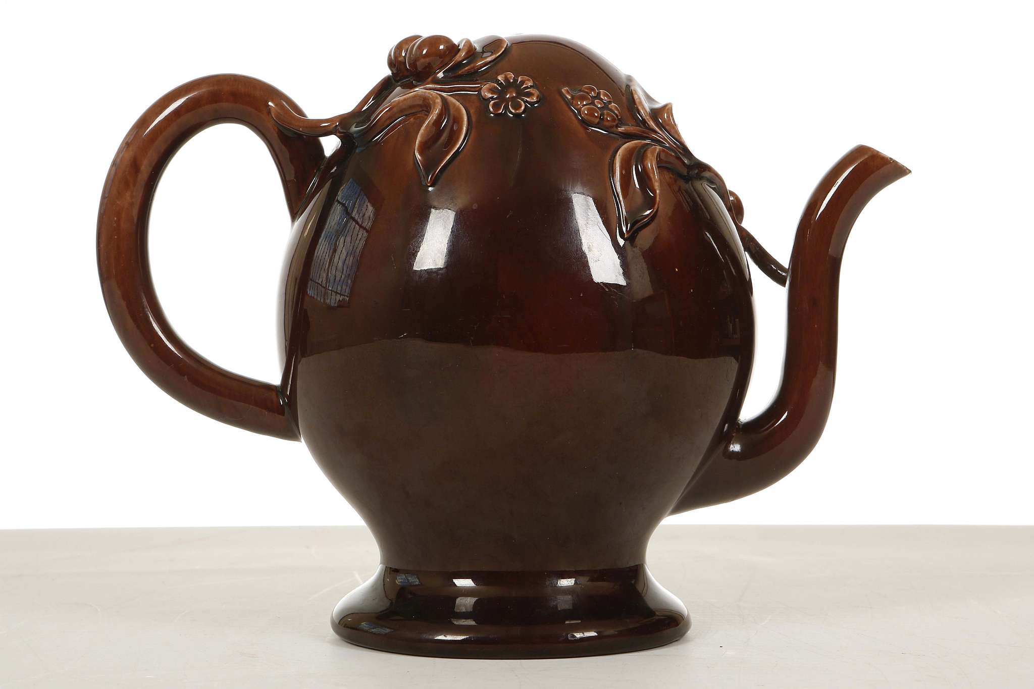 A BRAMELD CADOGAN TREACLE-GLAZE TEAPOT, circa 1810-30, the ovoid body applied with peaches,