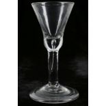 A PLAIN STEM GEORGIAN WINE GLASS, circa 1740, the thistle-shaped bowl with solid teared base, set on