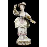 A MEISSEN MODEL OF A LADY, late 19th century, her arms outstreched holding a colourful garland of