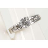 A 14k white gold and diamond set solitaire ring, the central claw set round cut stone being 0.85ct