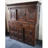 An antique oak court cupboard with carved decoration and 3 cupboards over 3 drawers and cupboard