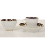 A COALPORT TRIO, circa 1800, each spiral-fluted and decorated with blue and gold borders, comprising