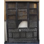 A large wooden screen with bobbin turned and lattice pierced panels