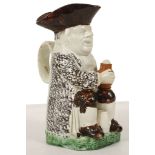 A STAFFORDSHIRE TOBY JUG, late 18th century, of Ordinary Wood type, modelled seated with a foaming