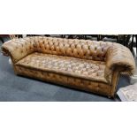 A brown button-back leather roll-arm chesterfield,