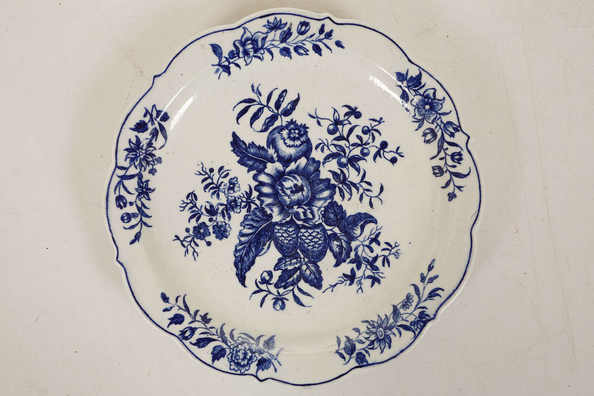 A CAUGHLEY PLATE, circa 1775, printed in blue with the 'Pine Cone Group' pattern, with a scalloped