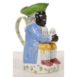 AN UNUSUAL 'BLACK MAN' TOBY JUG, circa 1830-40, of Ordinary type, modelled seated with a foaming jug