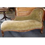 A Victorian carved walnut framed green velvet upholstered chaise longue