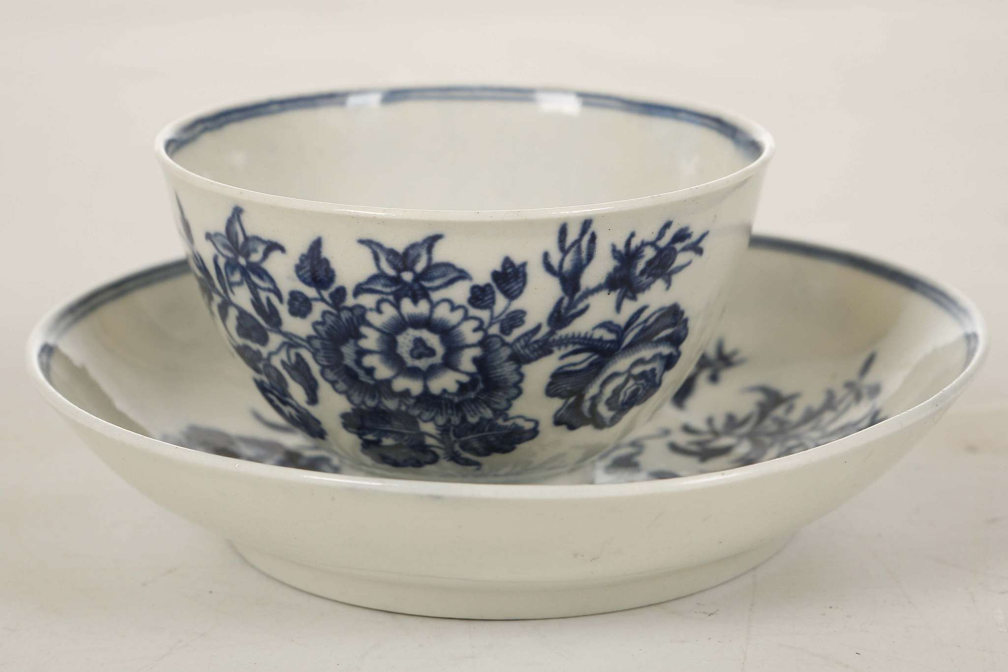 A WORCESTER TEABOWL AND SAUCER, circa 1770, printed in blue with the 'Three Flowers' pattern (the
