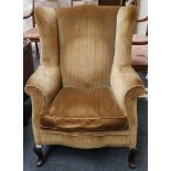 A wing back armchair, circa 1920, upholstered in gold draylon, on cabriole legs