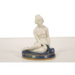 AN ART DECO ROYAL WORCESTER FIGURE OF A NUDE, dated 1923, modelled seated on a mottled blue circular