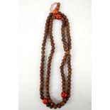 A Chinese beaded necklace, with circular wooden and coral beads, 63cm long