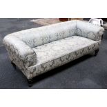 An Edwardian sofa, damask acanthus leaf decoration, roll arms, stub turned feet, ceramic castors