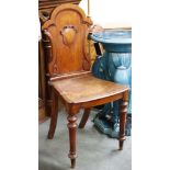 A Victorian, mahogany hall chair with shield decorated back rest, over a solid seat, raised on