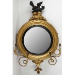 A 19th Century convex 'porthole' mirror / girandole dragon surmount on gilded rocks, twin arms,