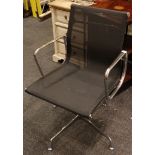 A modern chrome metal and black mesh upholstered desk chair, raised on an adjustable swiveling base