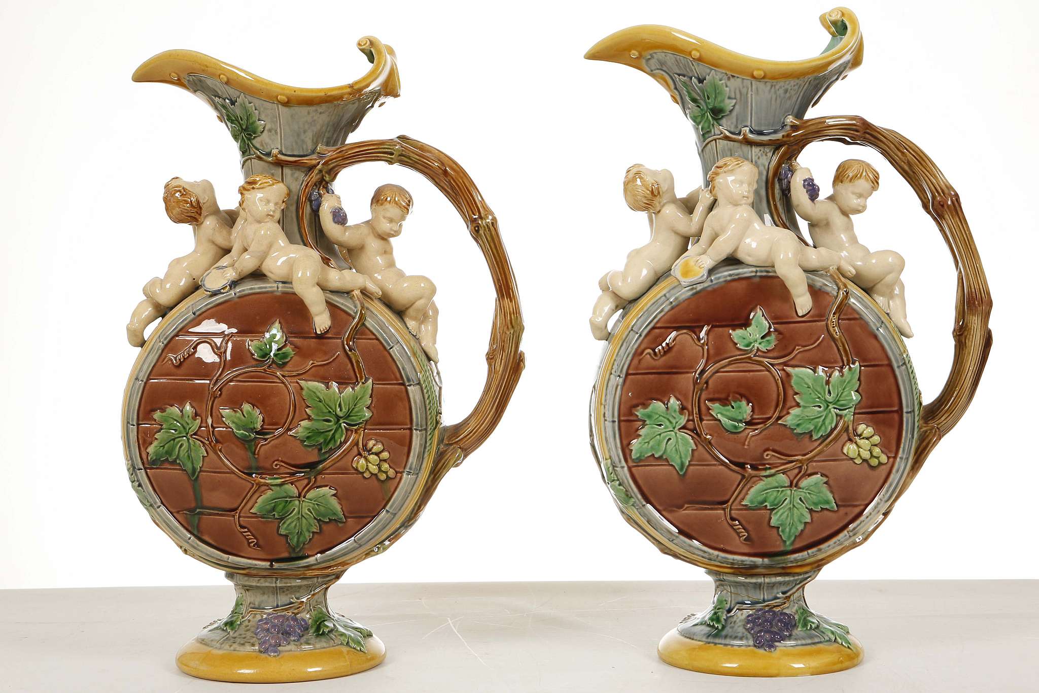 A PAIR OF MINTON MAJOLICA EWERS BY HUGHES PROTAT,