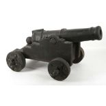 Cast 20th Century small cannon, 42cm barrel, wooden trunion and wheels, overall approx. 55cm