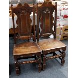 A pair of oak, 18th / 19th Century solid seat chairs, high double arch back, turned legs and