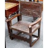 An 18th Century elbow chair, oak, leather embossed back and seat, brass studs, wave stretcher and