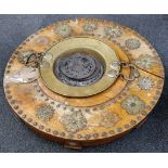 A Middle Eastern circular table with bronze and brass feet decoration and central brass food bowl,