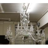 A splendid two tier cut glass chandelier, with nine scrolling arms, baluster stem, with drip pans