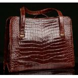 CARTIER CROCODILE HANDBAG, mid 20th century, deep red crocodile leather with stamped 9ct gold clasp,