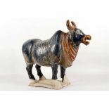 A ceramic archaic style study of a holy bull, two tone blue and brown glass, 35.5cm high