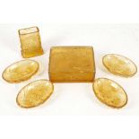 An amber glass trinket box, a matching set of four pin dishes and a small rectangular vase, each