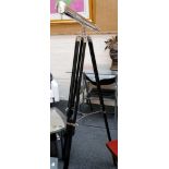 A chrome effect telescope, mounted on an adjustable ebonised tripod stand