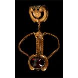 A c.1940's Karm pendant brooch, in the form of a fob seal in gilt metal and set with garnet coloured