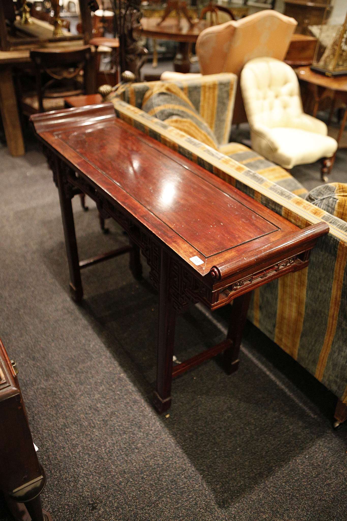 A Chinese alter table, rosewood finish, scroll ends, pierced 'Greek' key apron, block legs with