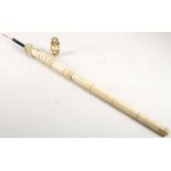 A carved bone fishing rod, with mermaid top