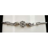 An 18ct white gold and diamond set bracelet, the central floral cluster flanked by channel set