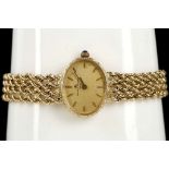 A ladies 14k gold cased, Baume Mercier Geneve dress watch, with oval gilt dial, engraved bezel and