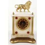 A 19th Century French alabaster and gilt metal mantel clock, the top surmounted by a lion