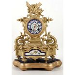 A French, empire style, gilt mantle clock, having decorated porcelain clock face and lower panel,