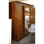 A mid 19th Century triple wardrobe, mahogany, arch panel doors flanking mirrored door revealing