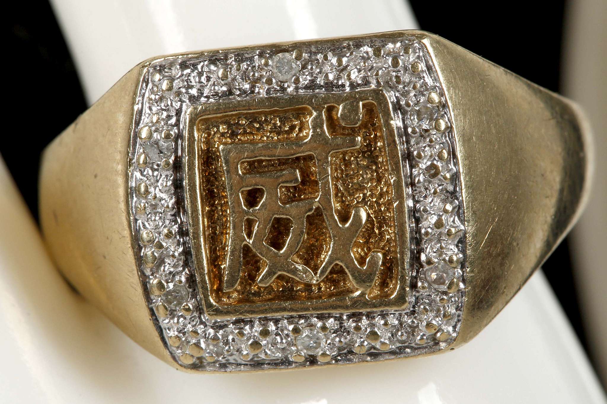 A yellow gold and diamond set ring, centred with Chinese character