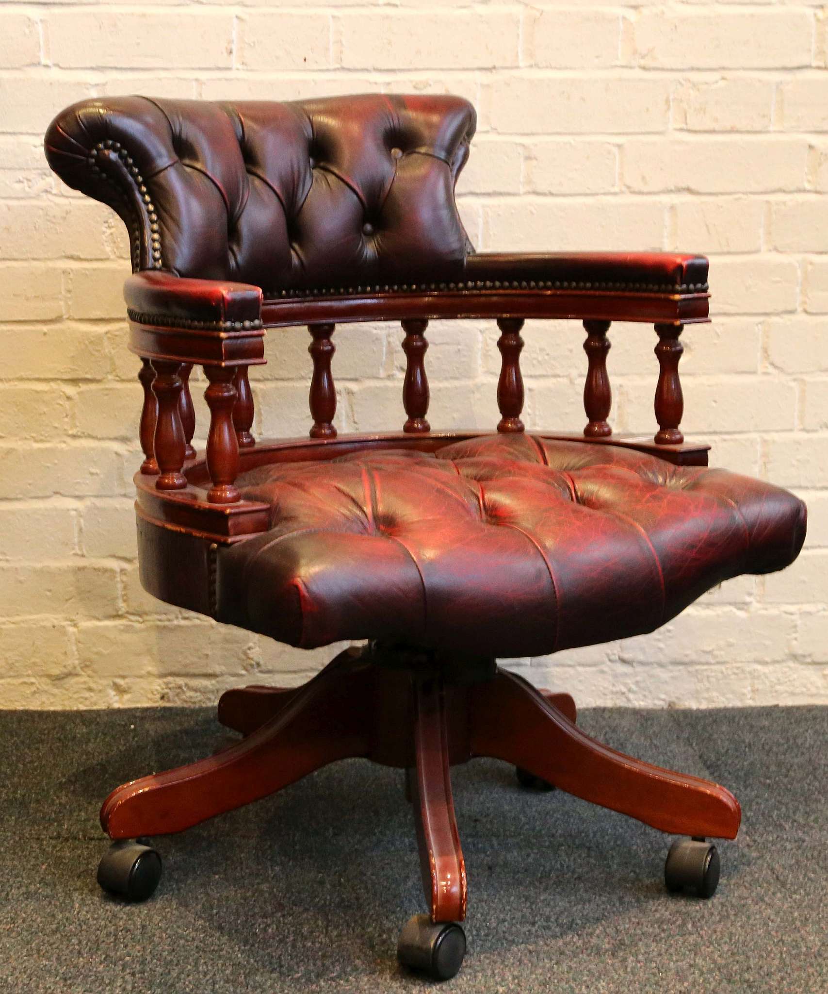 A captain's / office chair, claret buttonback and seat