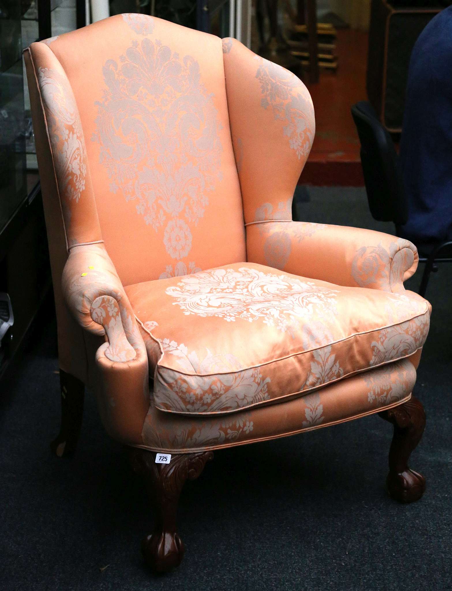 A George I style wing armchair, upholstered in ora