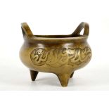 A Chinese brass incense burner, bronze twin handles, script to body, tri-pod legs, 13cm diameter