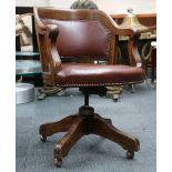 An oak Captain's chair with brown leather cloth ba