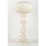 A 1920's alabaster table lamp, having a carved sha