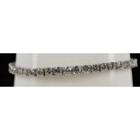 A 14ct white gold, fine quality diamond line brace